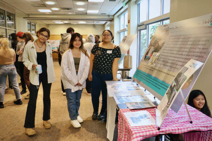 Students (from left) Kai McLean of Kensington CAPA and Nhi Ngo and Katherine Estivez of Girls High, present their projects during a climate storytelling festival at WHYY.