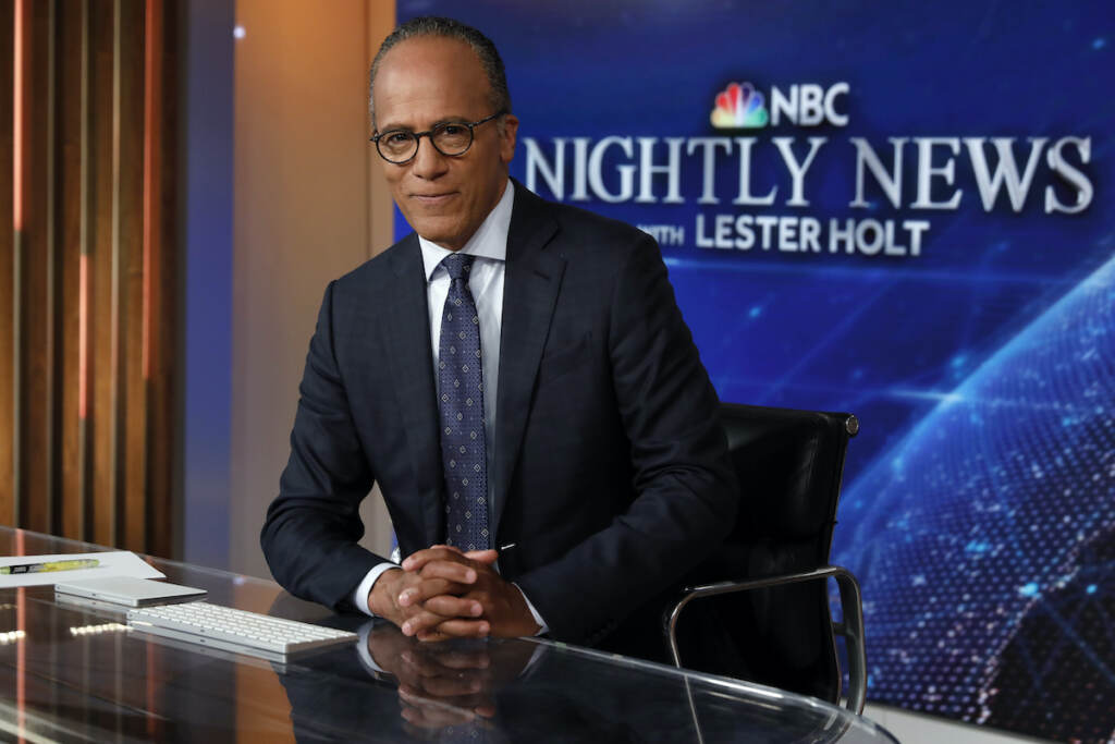 Lester Holt Lester Holt sits at the desk with a sign for NBC Nightly News in the background.