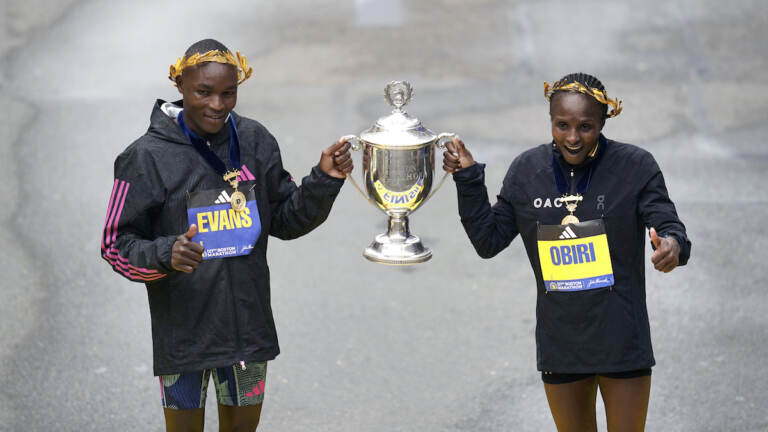 Evans Chebet (left) and Hellen Obiri, both of Kenya, pose on the finish line after winning the men's and women's division of the Boston Marathon