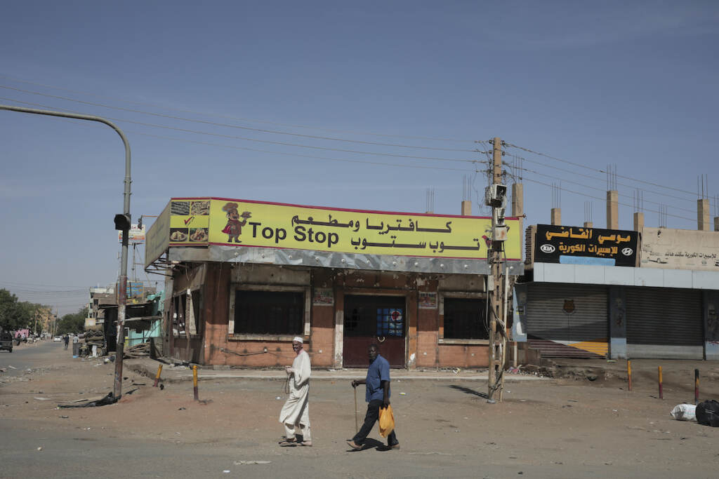 CORRECTION Sudan People walk past shuttered shops in Khartoum, Sudan