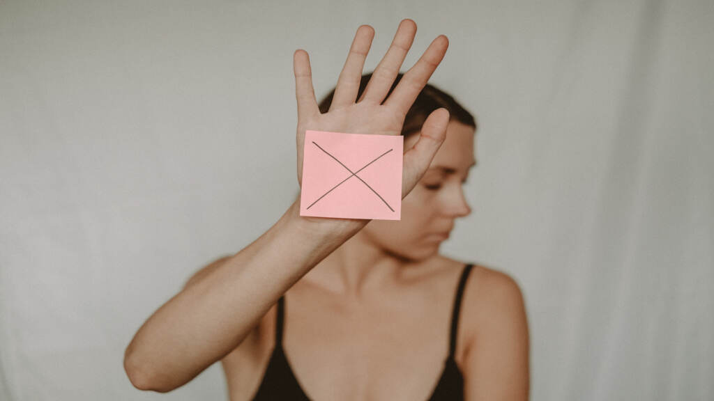 The-Pulse-04-21-23 Woman holding post it note with the letter X drawn on it