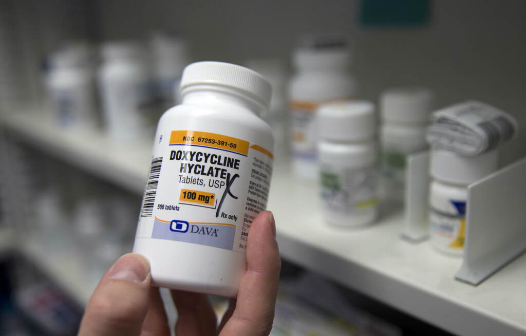 STD Prevention Pills A bottle of antibiotics is held in a pharmacy.