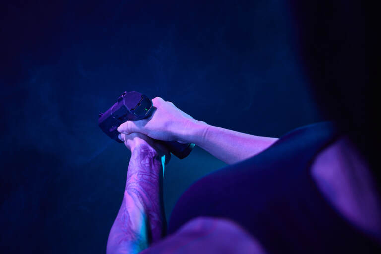 A person holds a gun in front of htem.