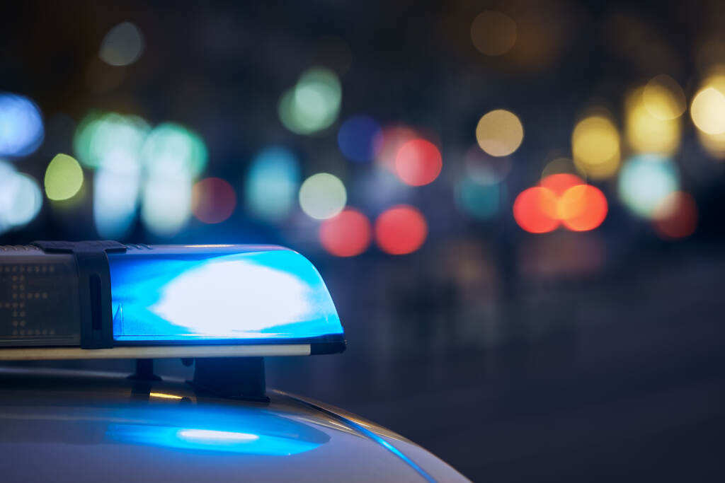 Blue Flasher Light Of Siren Of Police Car At Night City Street. Police car with siren flashing.