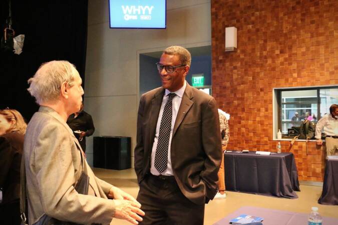 Philadelphia City Council candidate Christopher Gladstone Booth (right) talks with voters at a candidate convention hosted by WHYY. (Emma Lee/WHYY)