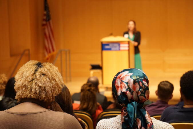 Aminah Collins (left) and Siani George (right) look towards a speaker onstage.