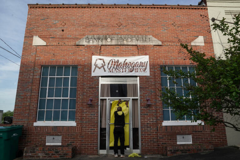 Norman Brooks covers the door of the Mahogany Masterpiece dance studio, the scene of Saturday's deadly mass shooting in Dadeville, Alabama