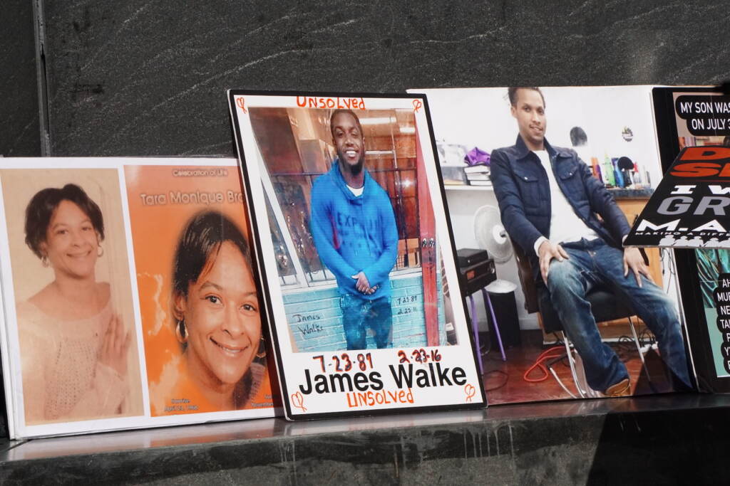 Posters featuring the faces of people lost to violence flank the rally stage