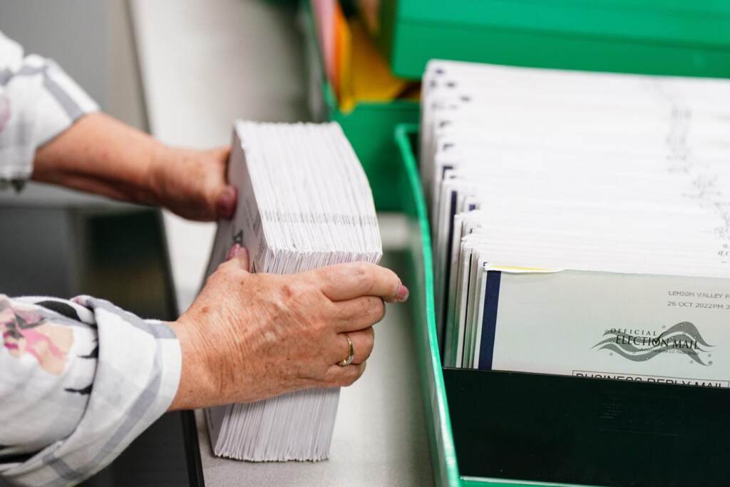 mail-vote-pa-spotlight Una persona organiza y cuenta papeletas por correo.
