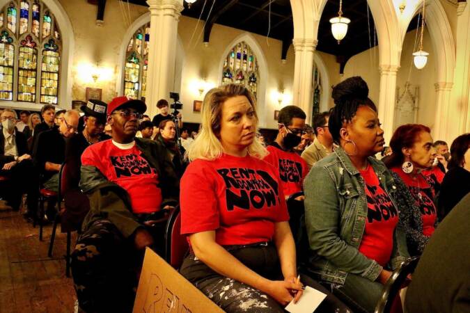 Members of the Philly Rent Control Coalition wear matching T-shirts as they sit in the audience at Broad Street Ministry.