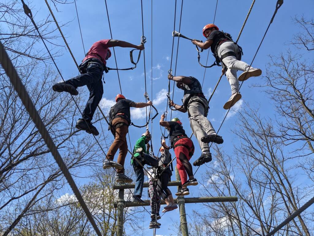 A group of people on a tightrope together as a team exercise.
