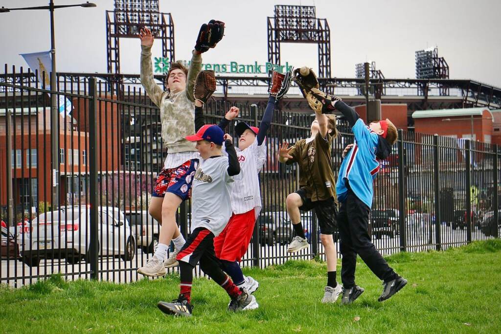 Kids play catch outside of the ballpark.