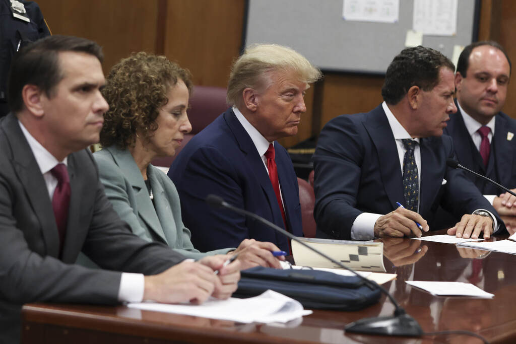 Trump Indictment Trump sits at court with his lawyers.