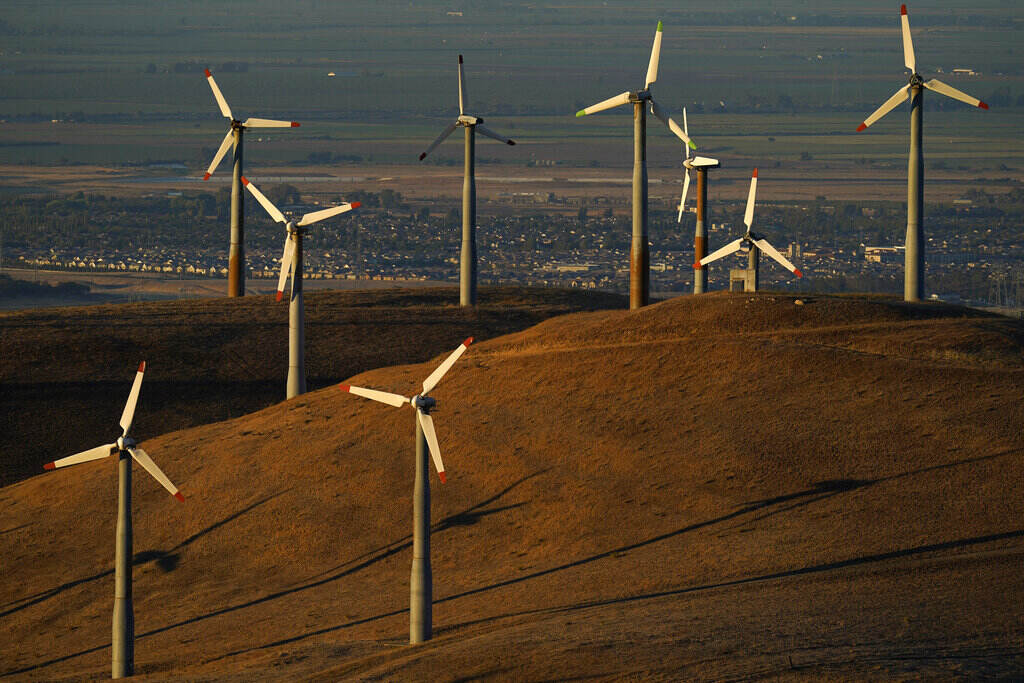 Climate Bill Wind turbines are visible on a hill at sunset.
