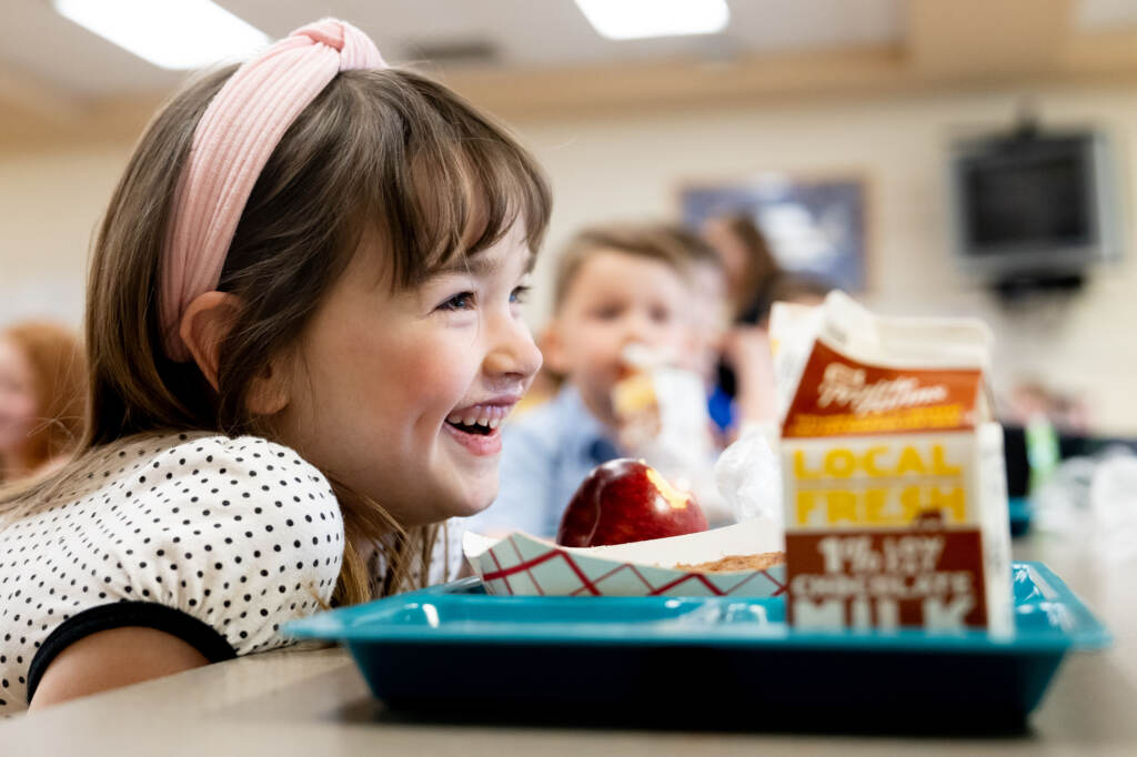 Amelia, a 5-year-old student at Oakville Elementary School, socializes during lunch in March at the school in Oakville, Mo. Kids who eat school meals tend to have a healthier diet. Young girl eating lunch in school cafeteria