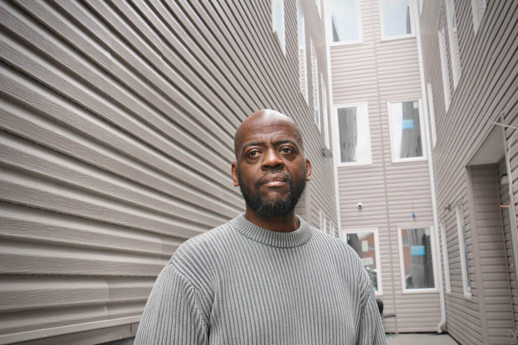 2023 03 23-e lee-dawud bey-philadelphia north broad-affordable housing developer exterior Dawud Bey poses for a photo in front of an apartment building.