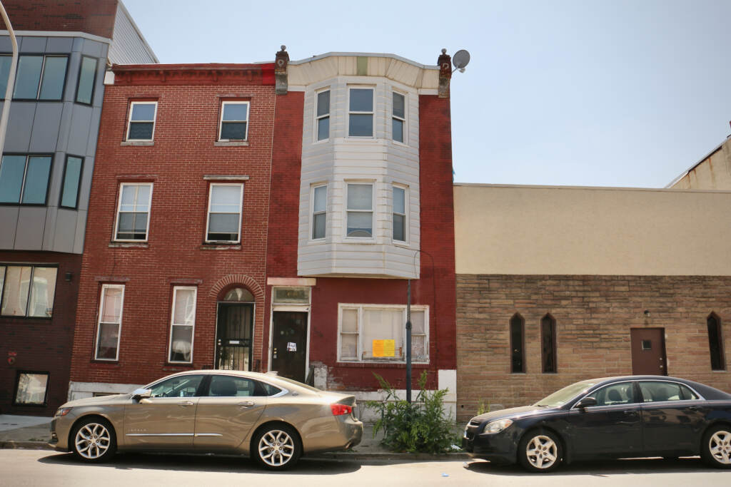 A rowhouse is visible from across the street.