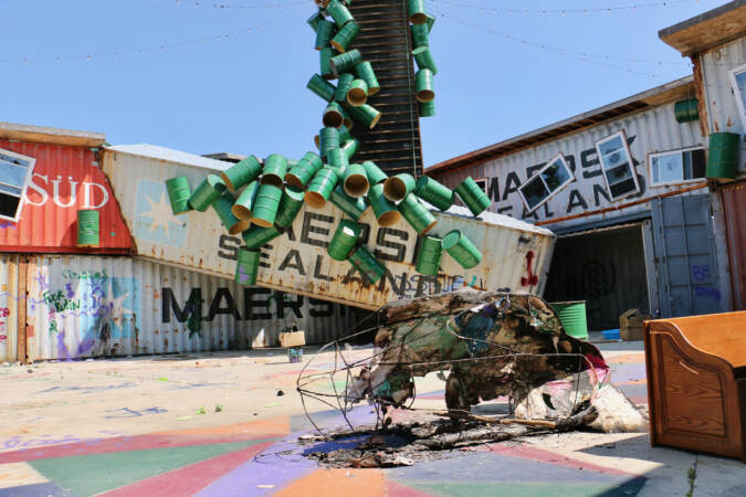 A paper mache figure sits outside of the former building of the insectarium.