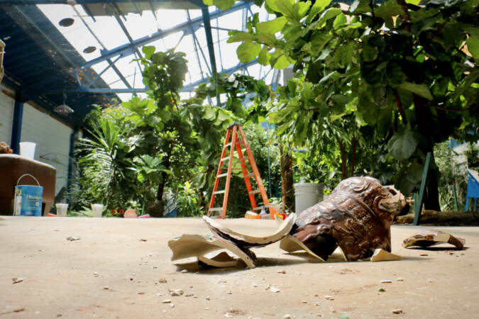 A shattered urn is visible on the ground.