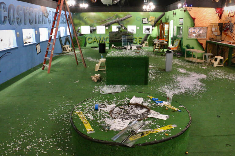 Shattered glass is everywhere on the floor of a large room.