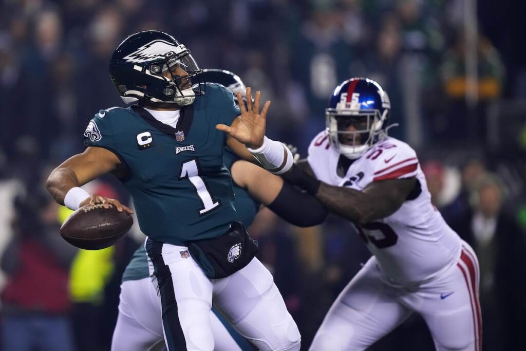 Philadelphia Eagles quarterback Jalen Hurts (1) throws a pass as New York Giants linebacker Jihad Ward (55) tries to rush in on him during the first half of an NFL divisional round playoff football game, Saturday, Jan. 21, 2023, in Philadelphia.