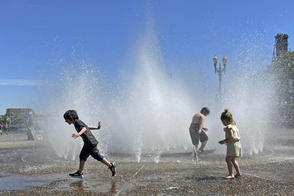 Pacific Northwest Heat Wave Children play in a fountain to cool off in downtown Portland, Ore., Friday, May 12, 2023. An early May heat wave this weekend could surpass daily records in parts of the Pacific Northwest and worsen wildfires already burning in western Canada, a historically temperate region that has grappled with scorching summer temperatures and unprecedented wildfires fueled by climate change in recent years.
(AP Photo/Claire Rush)