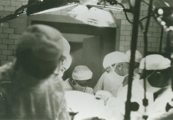 Surgeons at work in a black-and-white photo.