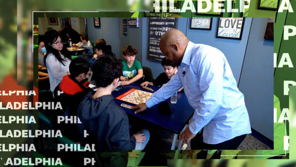 Man teaching children how to play scrabble