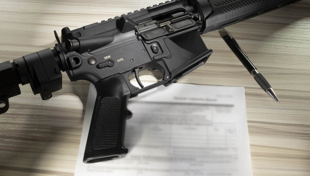 bigstock-Assault-Rifle An assault rifle is shown along with paperwork