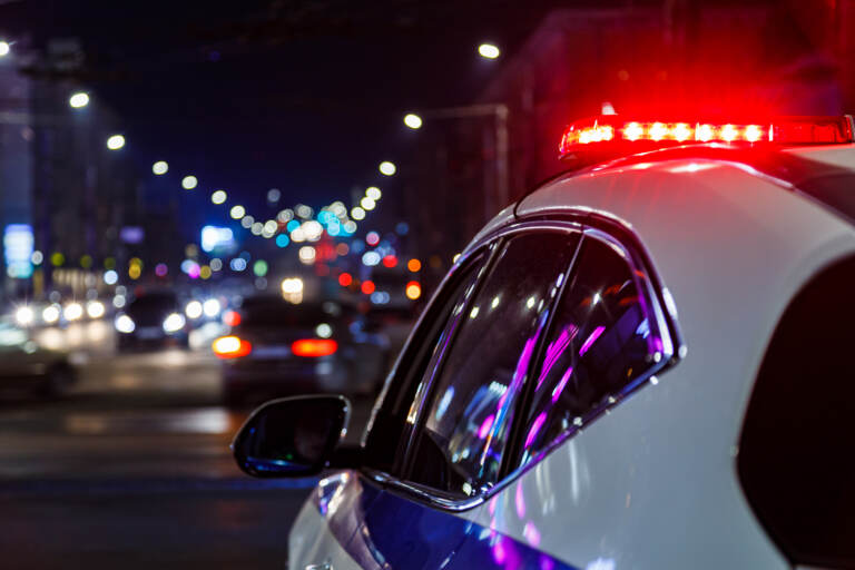Police car with siren flashing at night.