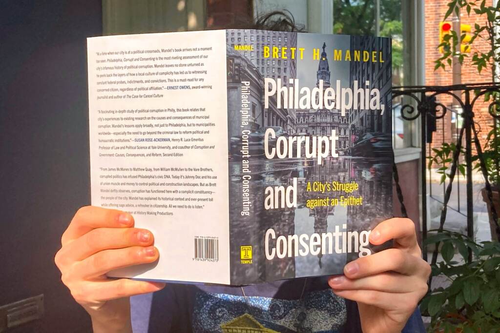 A person reading the book 'Philadelphia, Corrupt and Consenting'