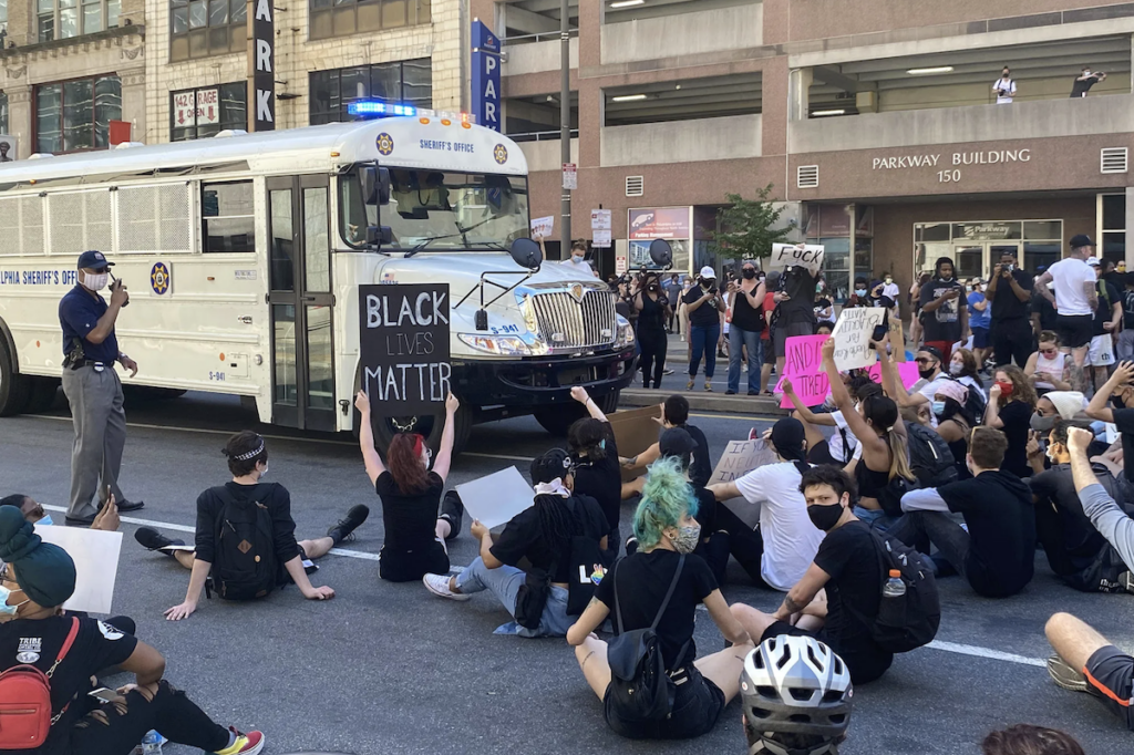 george-floyd-protest-blocking-bus-k-paynter-2020-05-30 Protesters sitting in the street, blocking a prison transport bus
