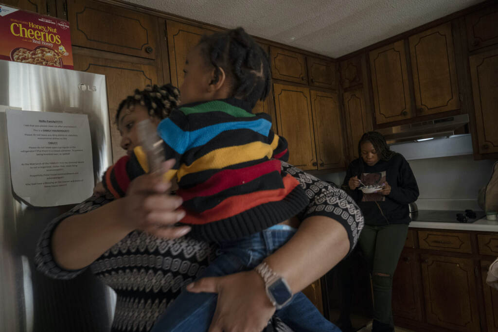 Angelica Lyons carries her son