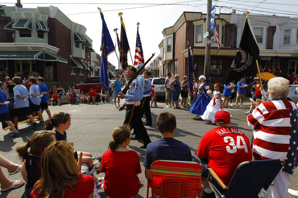 People watch veterans march past them in a Memorial Day parade.