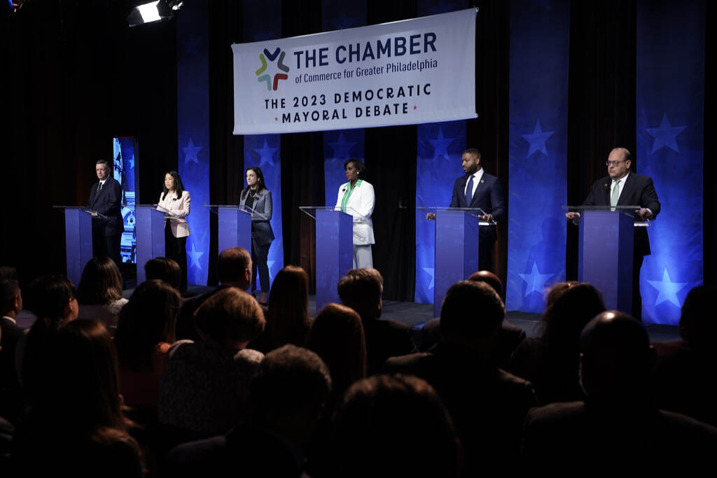 Philly mayoral candidates stand at podiums onstage.