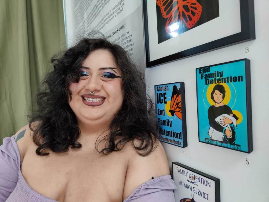 Cela Ixcopal poses for a photo next to one of his artworks.
