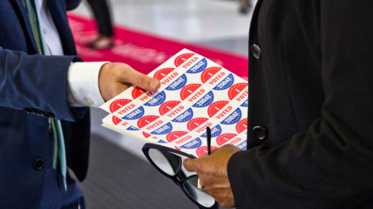 An election worker holds I Voted stickers