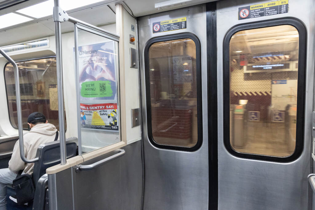 Inside one of SEPTA’s elevated trains. (Kimberly Paynter/WHYY) A person sits on the SEPTA subway.
