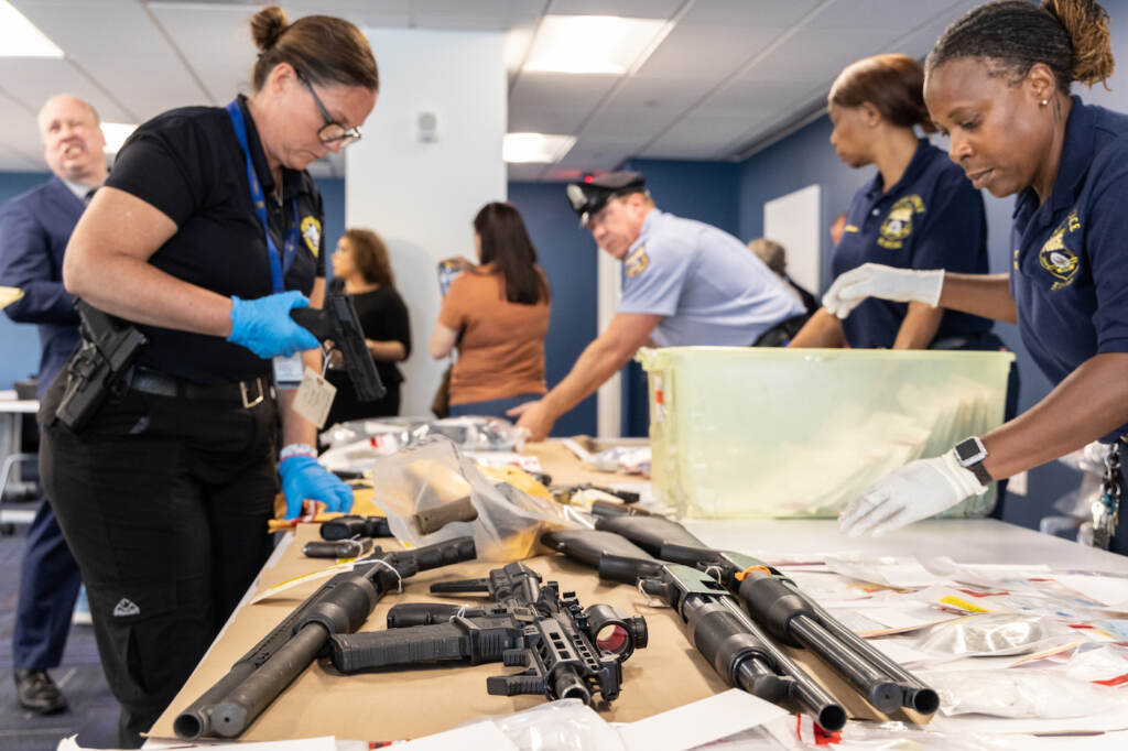06 25 2023 k paynter kensington narcotics bust press press conference Police officer handling confiscated guns.