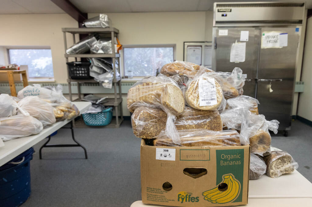 Donated breads at the Narberth Community Food Bank. (Kimberly Paynter/WHYY) Many bags of bread sit on a table in the food bank.