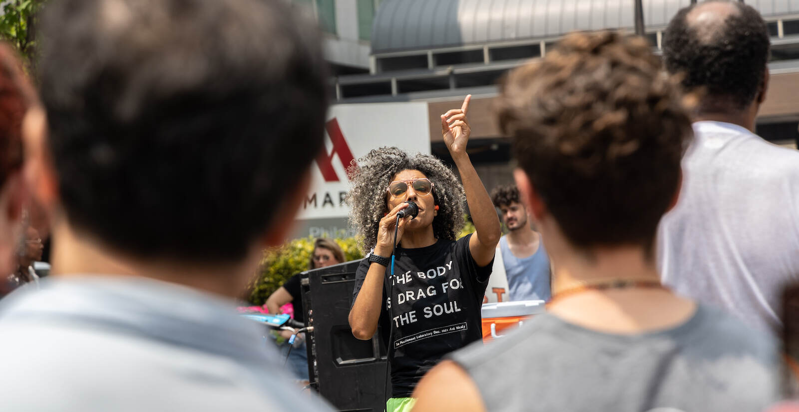 Sam Rise speaks into a mic at a protest against Moms for Liberty in Philly
