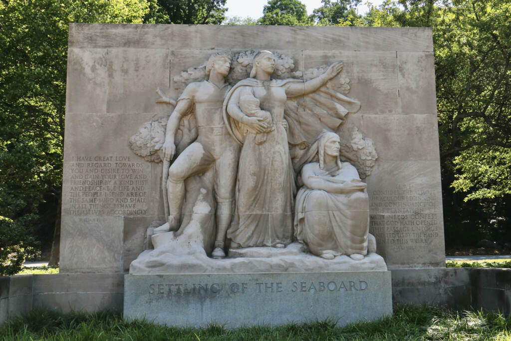 Sculpted figures are visible, with trees behind them.