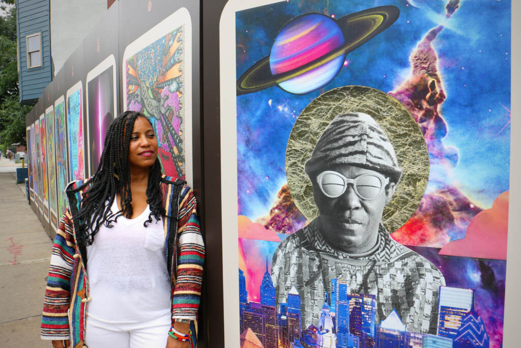 2023 06 23-e lee-li sumpter-philadelphia village for arts and humanities-village oracle afrofuturist Li Sumpter posing by a tarot card featuring Sun Ra.
