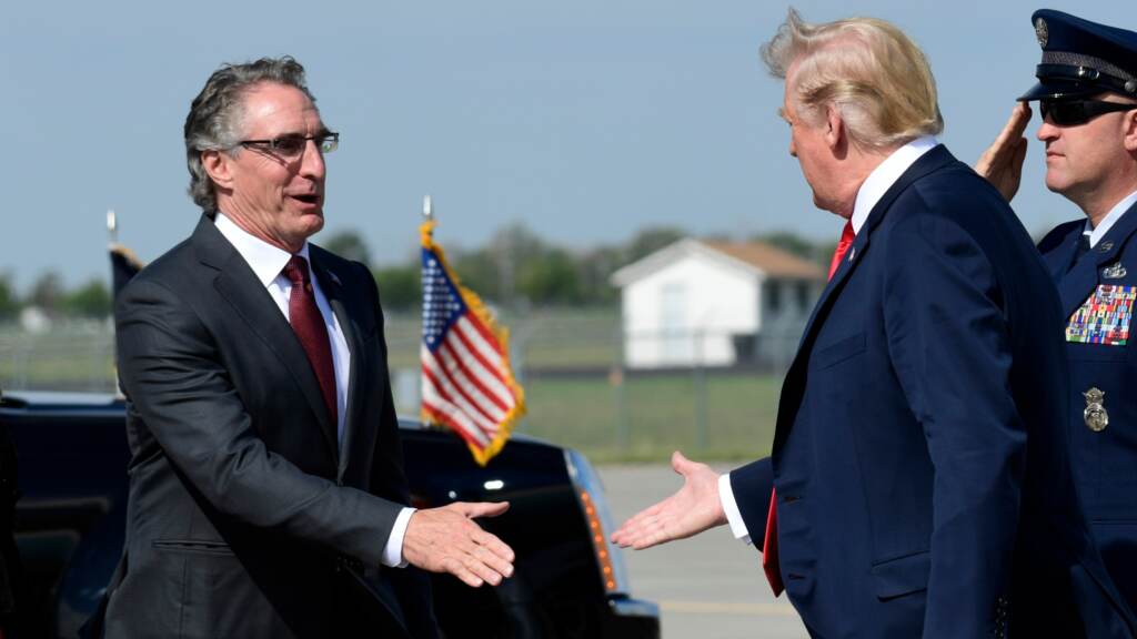 AP18250611298380 (1) President Donald Trump reaches out to shake hands with North Dakota Gov. Doug Burgum, and his wife Kathryn Helgaas Burgum after arriving at Hector International Airport in Fargo, N.D., Friday, Sept. 7, 2018. Trump is in Fargo to speak at a fundraiser