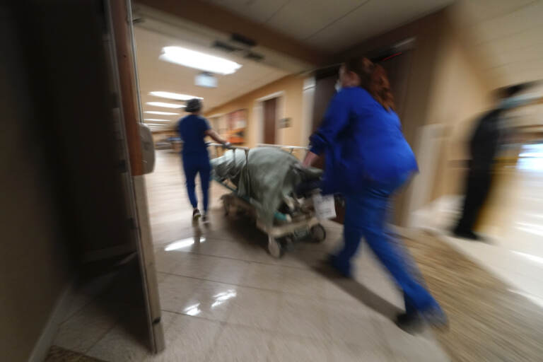 Medical staff move a COVID-19 patient who died to a loading dock to hand off to a funeral home van, at the Willis-Knighton Medical Center in Shreveport, La., Wednesday, Aug. 18, 2021. (AP Photo/Gerald Herbert)