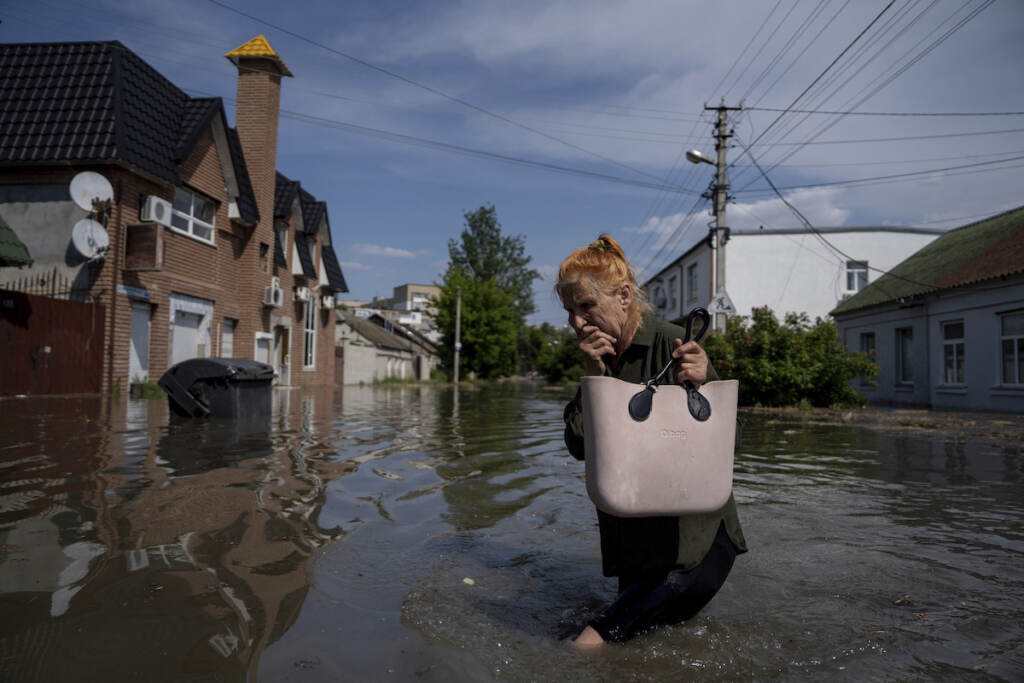 Russia Ukraine War A local resident makes her way through a flooded road after the walls of the Kakhovka dam collapsed overnight, in Kherson, Ukraine
