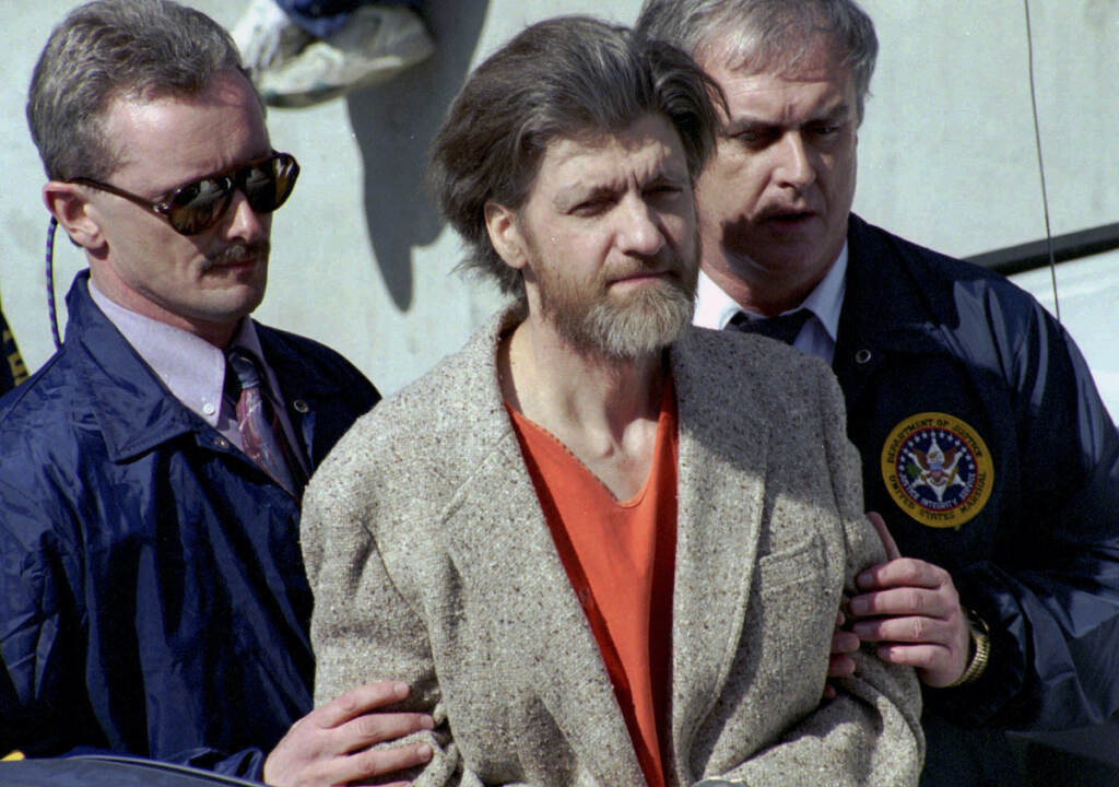 Obit Ted Kaczynski In this April 4, 1996 file photo, Ted Kaczynski, better known as the Unabomber, is flanked by federal agents as he is led to a car from the federal courthouse in Helena, Mont. Kaczynski, known as the “Unabomber,” has died in federal prison, a spokesperson for the Bureau of Prisons told The Associated Press on Saturday, June 10, 2023. (AP Photo/John Youngbear, File)