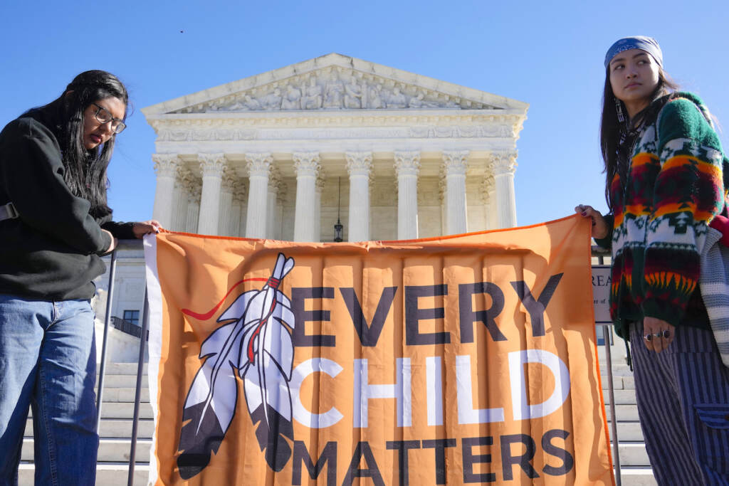 Demonstrators stand outside of the U.S. Supreme Court, as the court hears arguments over the Indian Child Welfare Act on Nov. 9, 2022, in Washington.