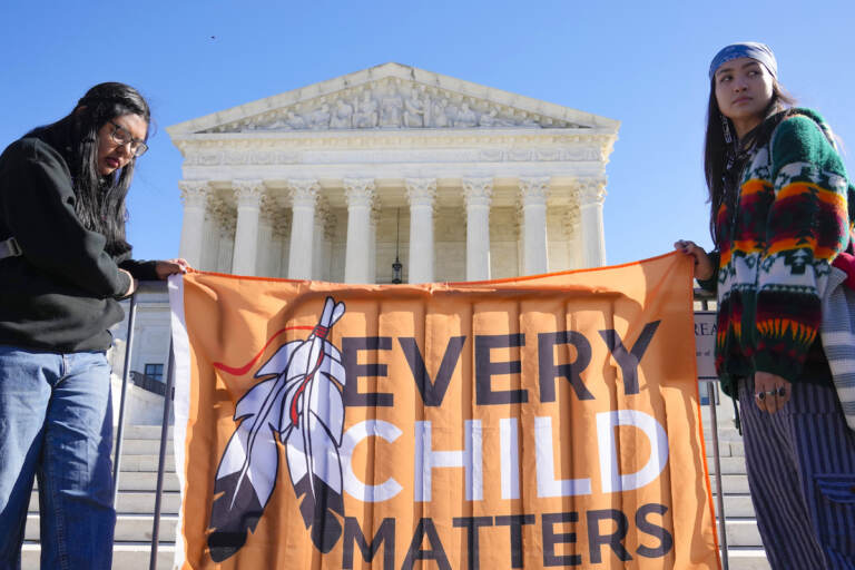 Demonstrators stand outside of the U.S. Supreme Court, as the court hears arguments over the Indian Child Welfare Act on Nov. 9, 2022, in Washington.