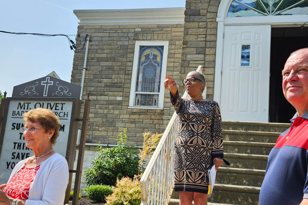 C. Adrienne Rhodes, co-founder of the Preserving Black Haddonfield History Project, stands on the steps of Mount Olivet Baptist Church and Parsonage in Haddonfield, N.J., on June 19, 2023. (Nicole Leonard/WHYY)